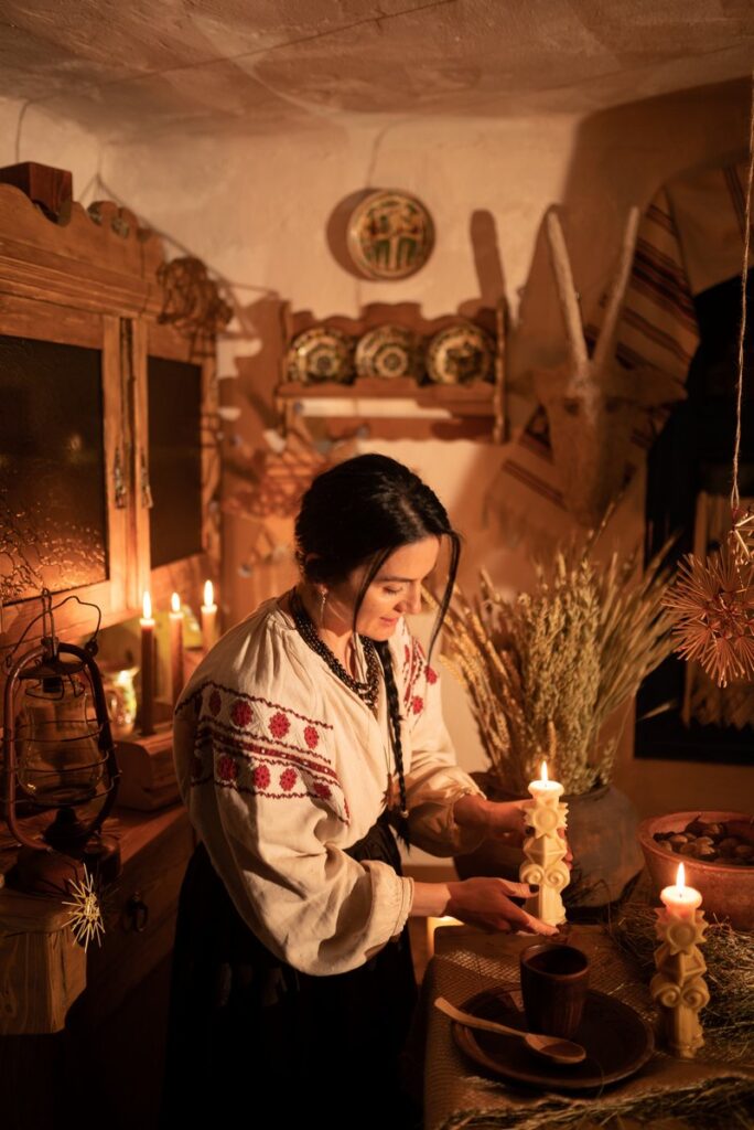 Дівчина у вишиванці запалює різдвяну свічку на Святвечір